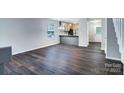Open-concept living room with modern gray walls and elegant, dark laminate wood flooring throughout at 3919 Briarhill Dr, Charlotte, NC 28215