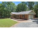 Charming brick home with manicured landscaping, attached garage, and a lovely covered front porch at 3943 Peggy Ln, Mint Hill, NC 28227