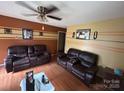 Relaxing living room featuring a ceiling fan, hardwood floors, and comfortable couches at 407 Alton St, Monroe, NC 28110