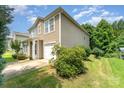 Low angle view of a charming two-story home with tidy landscaping and a one-car garage at 4462 Kellybrook Dr, Concord, NC 28025