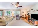 Bright living room with neutral walls, plush carpeting, ceiling fan, and comfortable furniture at 4462 Kellybrook Dr, Concord, NC 28025