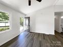 Clean living room featuring wood-look flooring, a large window, and an open doorway to a bedroom at 4903 Jamee Dr, Gastonia, NC 28056