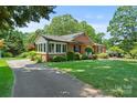 Exterior side view of a beautiful brick home with a well-kept lawn and a cozy sunroom at 747 9Th Nw St, Hickory, NC 28601