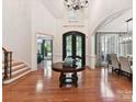 Grand foyer featuring hardwood floors, high ceilings, elegant lighting, and a striking front door at 9000 Whirlaway Ln, Waxhaw, NC 28173