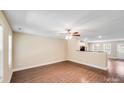 Bright and airy living room with light walls, wood floors, ceiling fan, and open access to the kitchen at 115 Dove Sw Ave, Concord, NC 28025