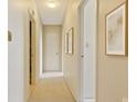 Inviting hallway with neutral paint, carpet flooring, and decorative art at 1300 Reece Rd # 305, Charlotte, NC 28209