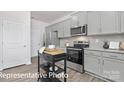 Bright kitchen showcasing stainless appliances, granite counters, gray cabinetry, and functional island at 1339 37Th Avenue Ne Ln, Hickory, NC 28601