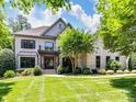 Beautiful brick home showcasing lush green lawn, inviting entryway, and charming balcony at 18618 Rollingdale Ln, Davidson, NC 28036