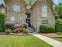 A welcoming front entrance with brick and stone facade, and lush landscaping at 213 Cowboys Cir, Rock Hill, SC 29732