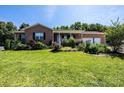 Attractive brick home with a cozy covered porch, lush landscaping, and well-kept front lawn at 4128 River Run Cir, Hickory, NC 28602