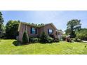 Beautiful brick home with a well-manicured lawn, mature landscaping, and a welcoming front porch at 4128 River Run Cir, Hickory, NC 28602