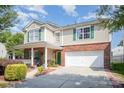 Inviting two-story home showcasing a front porch, green shutters, brick detailing, and a two-car garage at 4732 Meadowfield Rd # L35, Charlotte, NC 28215