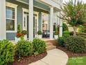 Inviting front porch features elegant columns, comfortable seating, and lush landscaping at 500 Landau Rd, Waxhaw, NC 28173