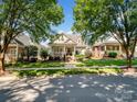 Suburban home boasts lush landscaping and a charming porch, nestled in a quiet neighborhood at 5572 Yorke Nw St, Concord, NC 28027