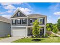 Attractive two-story home with gray siding and a cozy front porch seating area at 7025 Amberhouse Dr, Charlotte, NC 28212