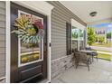 Close-up of a welcoming front door with a decorative wreath and cozy porch seating area at 7025 Amberhouse Dr, Charlotte, NC 28212
