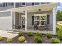 Inviting front porch featuring seating, decorative plants, and stylish stone accents at 7025 Amberhouse Dr, Charlotte, NC 28212