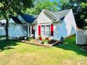 Well-maintained home featuring lush green lawn and flower beds, and a white picket fence at 7215 Wingstone Ln, Charlotte, NC 28262