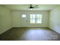 Bright and airy living room featuring sleek flooring and modern ceiling fan at 9208 Detroiter Dr, Huntersville, NC 28078