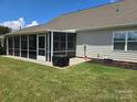 Backyard view featuring a screened-in porch and well maintained lawn at 1224 Dali Blvd, Mount Holly, NC 28120