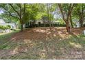 Well-manicured front yard with a charming home featuring symmetrical windows at 12325 Woodside Falls Rd, Pineville, NC 28134