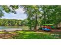 Scenic lake view with colorful kayaks on the grassy shore, with green trees in the background at 126 Aqua Dr, Mooresville, NC 28117