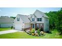 Charming two-story home with attached garage, lush lawn, and beautiful front yard landscaping at 139 Sheep Path Dr, Mooresville, NC 28115