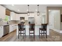 Modern kitchen with stainless steel appliances, granite countertops, and three counter chairs at 139 Sheep Path Dr, Mooresville, NC 28115