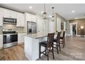 Modern kitchen with stainless steel appliances, granite countertops, and counter chairs at 139 Sheep Path Dr, Mooresville, NC 28115