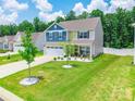 Aerial view of charming two-story home with landscaped yard and driveway at 154 Tanner Loop, Troutman, NC 28166