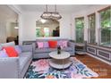 Bright living room with hardwood floors, stylish furniture, and elegant light fixtures at 2273 Aston Mill Pl, Charlotte, NC 28273