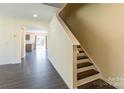 View of the entry hallway with wood laminate flooring and staircase leading to the upper level at 2357 Riding Trail Rd, Gastonia, NC 28054