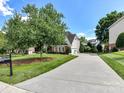 Long driveway leading to a home with a well-manicured lawn and mature trees at 27246 Preston Pl, Fort Mill, SC 29707