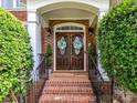 Charming brick home featuring a wooden front door with decorative wreaths and black iron handrails at 27246 Preston Pl, Fort Mill, SC 29707