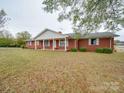 Charming single-story brick home featuring a classic covered front porch and lush front lawn at 3113 Old Pageland Marshville Rd, Wingate, NC 28174