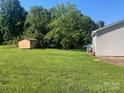 Spacious backyard featuring a storage shed, a lush lawn, and mature trees at 3973 English Oak Dr, Lincolnton, NC 28092