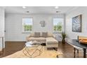Bright living room boasts a stylish sofa, unique coffee table, and hardwood floors at 404 Wakefield Dr # C, Charlotte, NC 28209