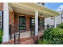 Inviting front porch with brick steps, white columns, and cozy seating at 512 Veloce Trl, Fort Mill, SC 29715