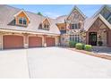 A spacious three-car garage with carriage doors complements the elegant stone and brick facade of this home at 600 Beauhaven Ln, Waxhaw, NC 28173