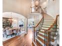 The foyer features a grand staircase, hardwood floors, elegant lighting, and access to the dining and living spaces at 600 Beauhaven Ln, Waxhaw, NC 28173