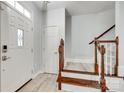 Bright foyer with hardwood floors, staircase with wooden banister, and a coat closet at 713 Torrey Pines Ln, Fort Mill, SC 29715