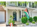 Inviting front porch featuring a storm door, lovely landscaping, and vibrant decor at 713 Torrey Pines Ln, Fort Mill, SC 29715