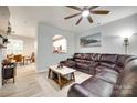 Spacious living room with a ceiling fan, large leather sectional, and open access to the kitchen at 713 Torrey Pines Ln, Fort Mill, SC 29715