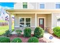 Inviting covered front porch showcasing manicured landscaping and a stylish front door at 7339 Dover Mill Sw Dr, Concord, NC 28025
