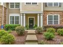 Inviting entryway with manicured landscaping and a classic black door flanked by white columns and stone accents at 8232 Sunset Hill Rd # Th88, Waxhaw, NC 28173