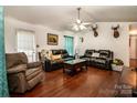 Cozy living room featuring hardwood floors, dark leather sofas, and a ceiling fan at 958 Hillard Ln, Lincolnton, NC 28092