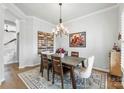 Bright dining room features hardwood floors, elegant lighting, a rustic table, and stylish decor at 11317 Fullerton Place Nw Dr, Huntersville, NC 28078