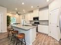 Bright kitchen featuring a large island with granite countertops and seating at 11807 Midnight Way, Huntersville, NC 28078