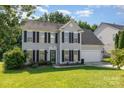 Charming two-story home with black shutters, green lawn, and attached two-car garage on a sunny day at 12250 Wallace Ridge Dr, Charlotte, NC 28269