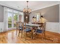 Elegant dining room featuring a glass table, chandelier, and large windows at 13101 Kensworth Ct, Charlotte, NC 28277